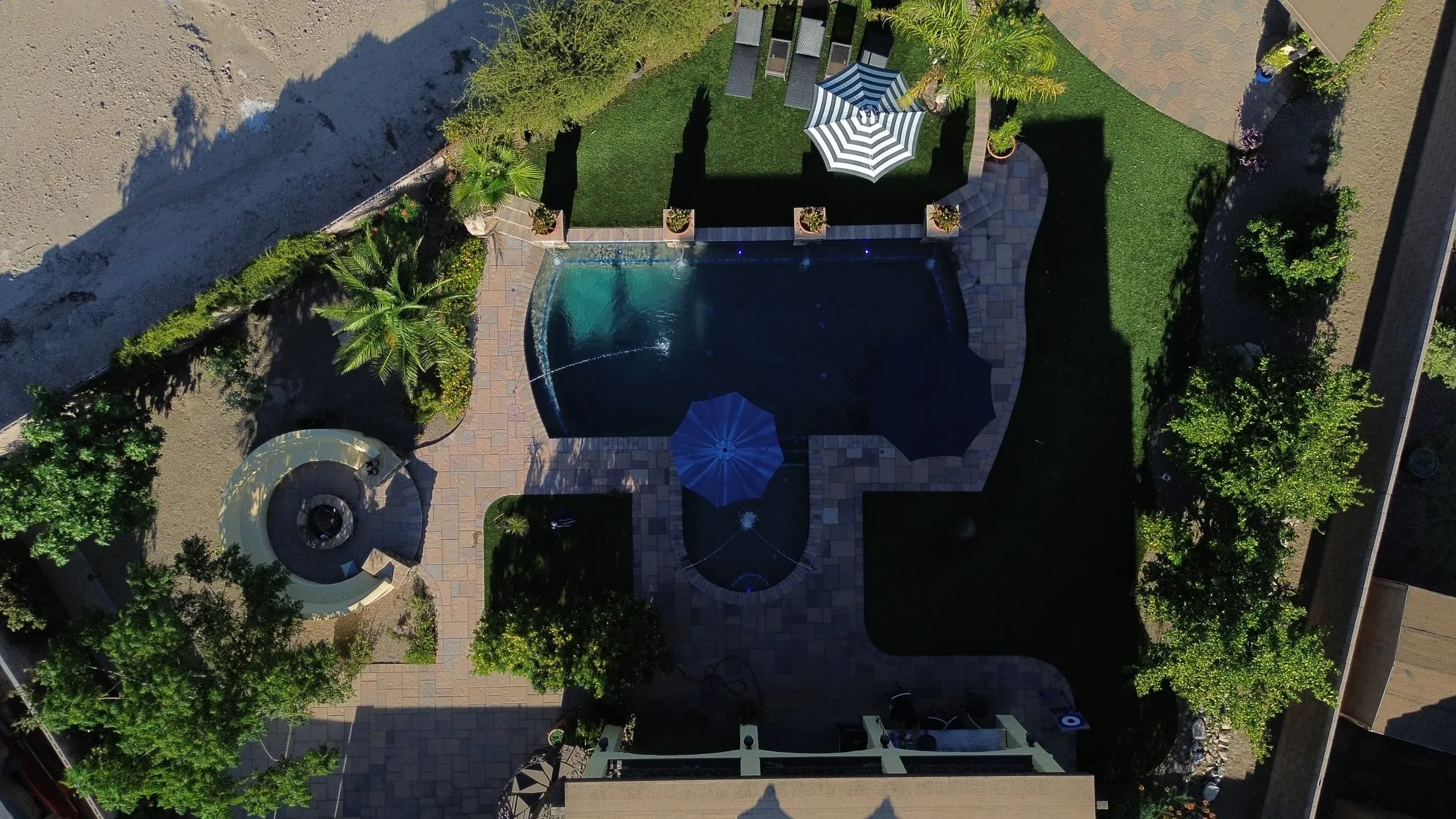 Aerial view of a freeform pool, paver deck and fire pit in a Tucson backyard